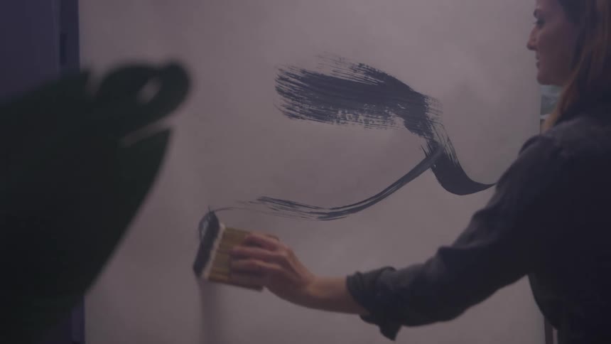Woman with a paintbrush painting a canvas