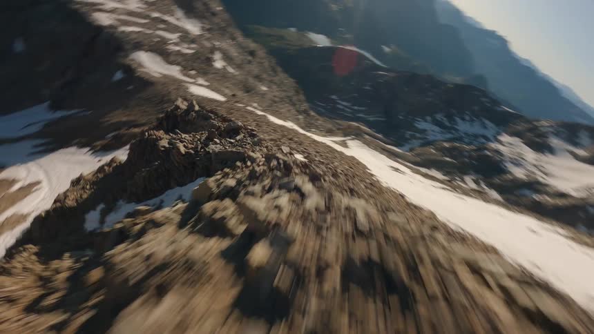 Mountain range with rocky slopes partially covered in snow at sunset