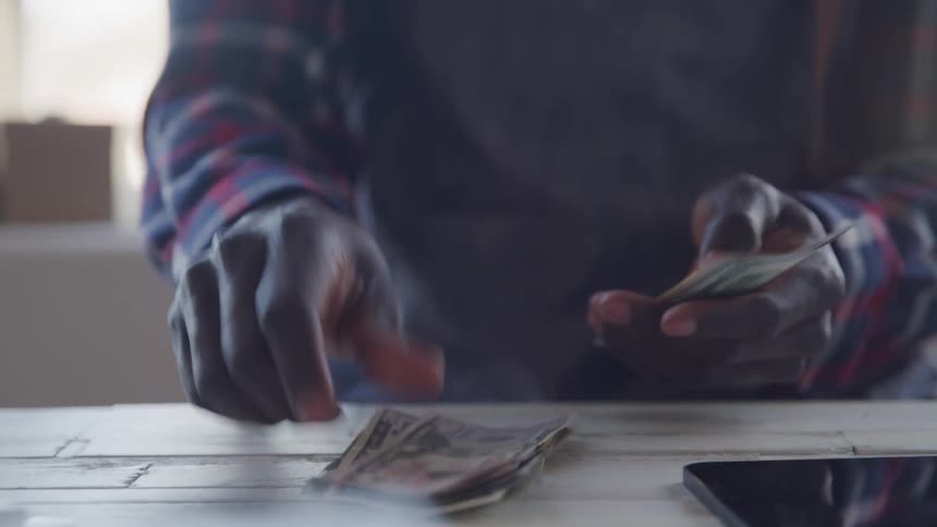 The man counts out money by the tablet