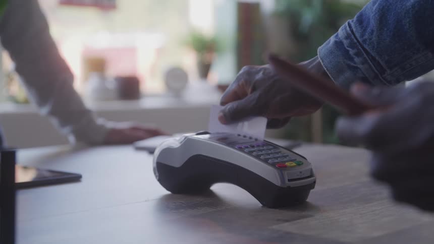 The man slides his credit card to pay