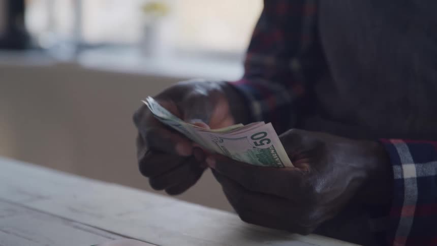 A man is counting a stack of cash