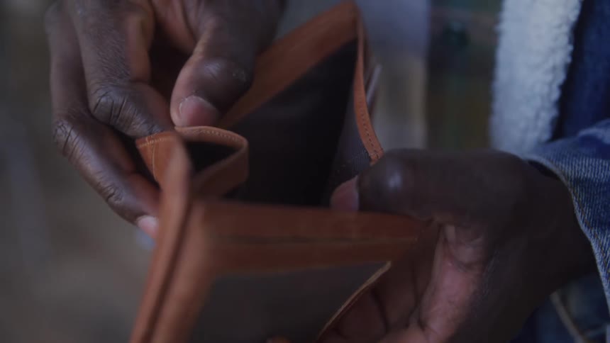 The man flips through his empty wallet