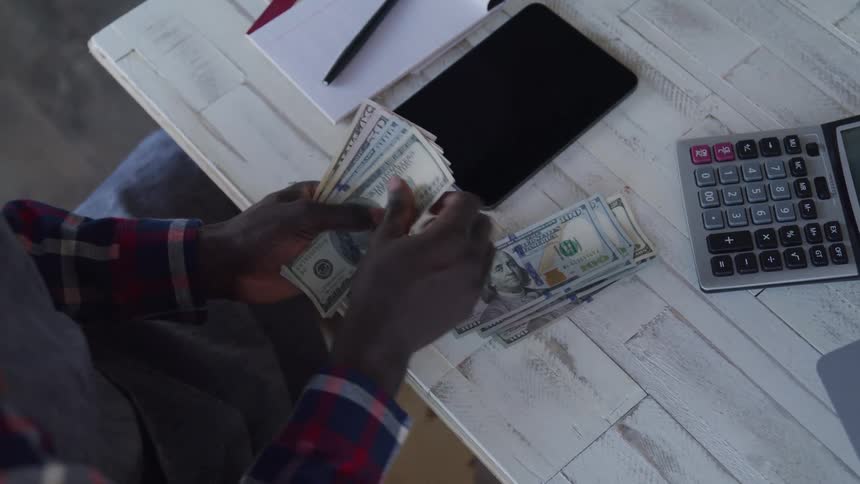 The worker is counting money in the cafe