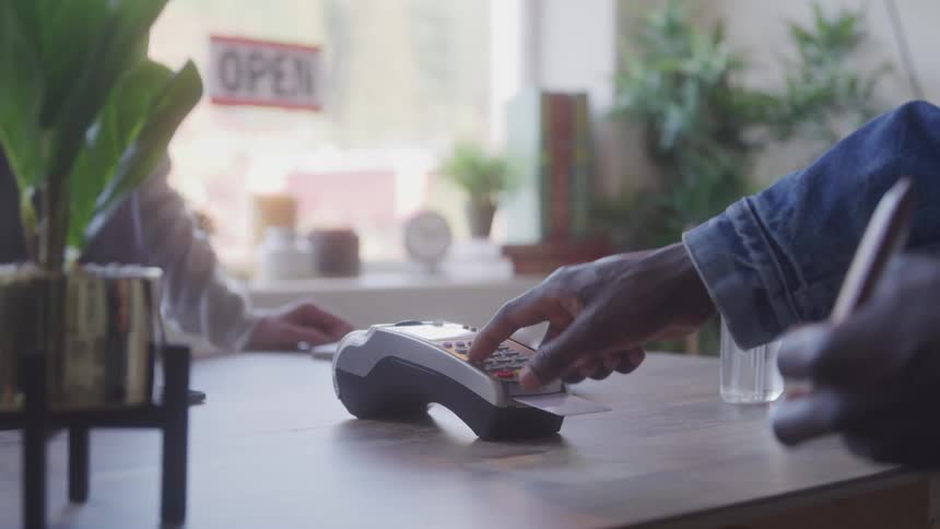 A person puts their credit card into a payment device
