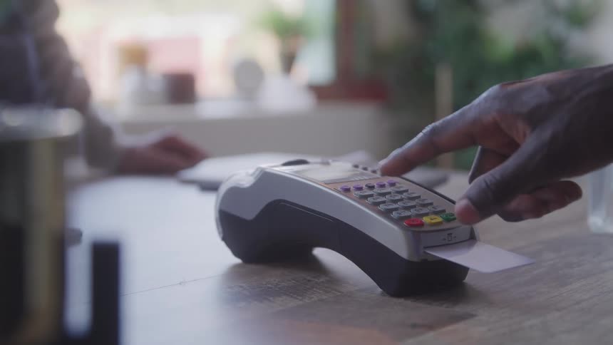 The man inserts the card and presses buttons on the payment processor