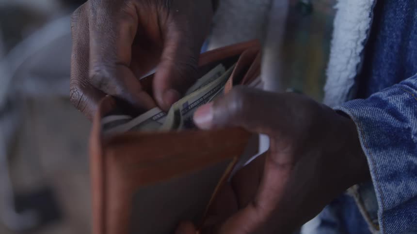 A man checking his wallet inside a store to pay for a product