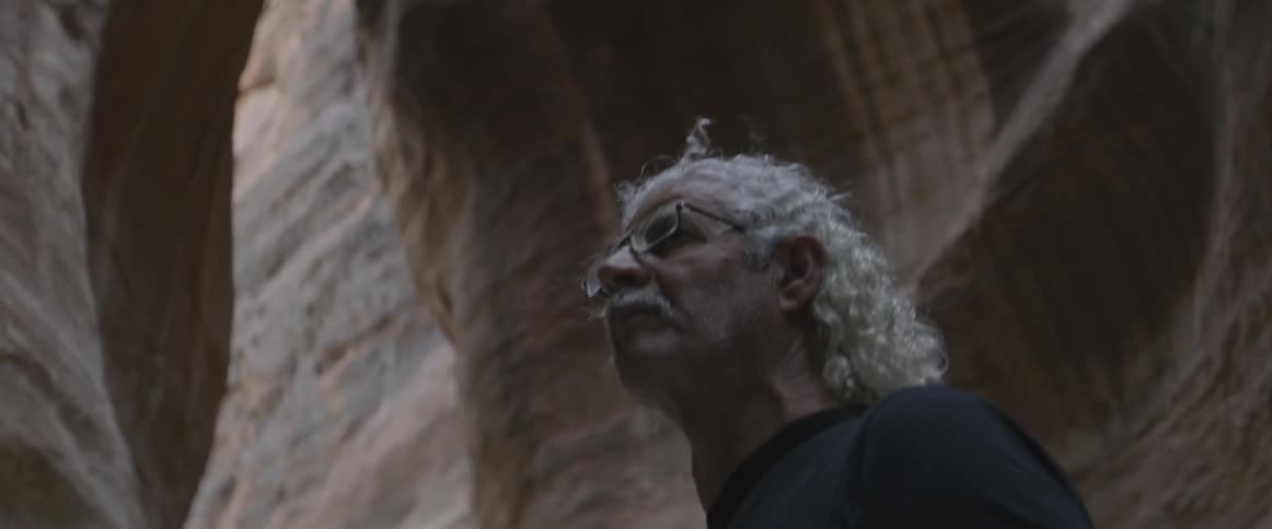 A man walks slowly in a cavern