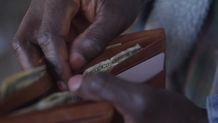 A man rifles through his wallet