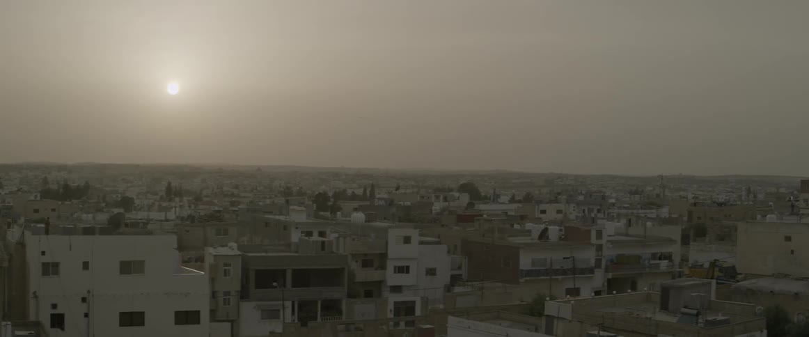 The sun shines over city buildings
