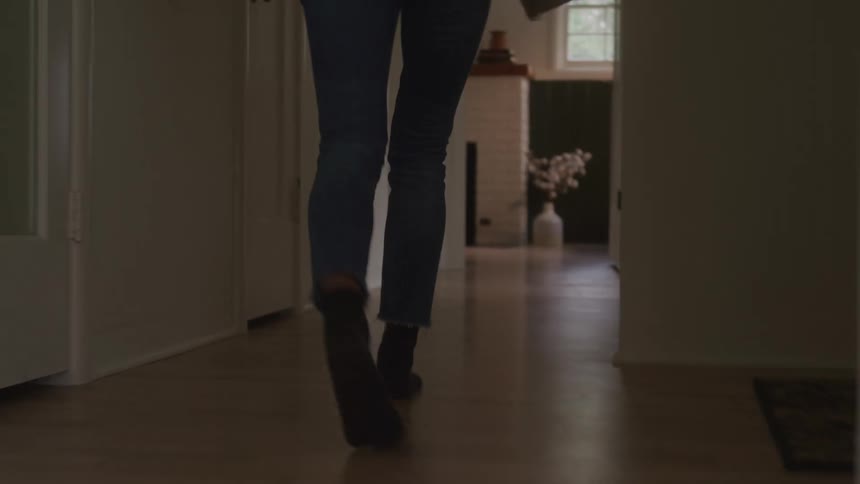 A woman angrily walks into another room slamming the door behind her