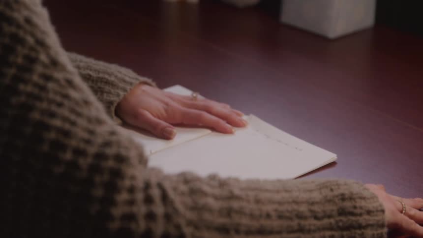 A woman writes at a desk