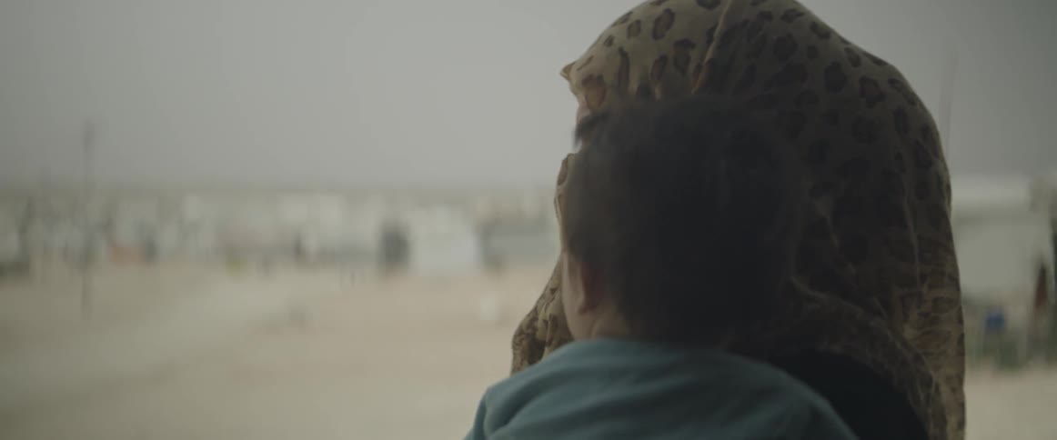 A woman holding a child looks around