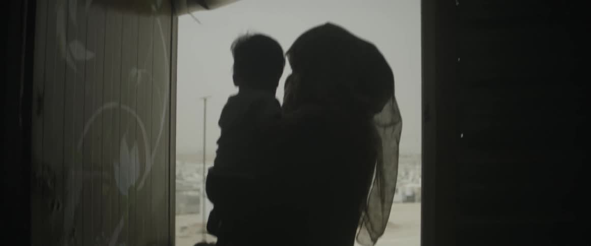 A woman is holding a child near a doorway