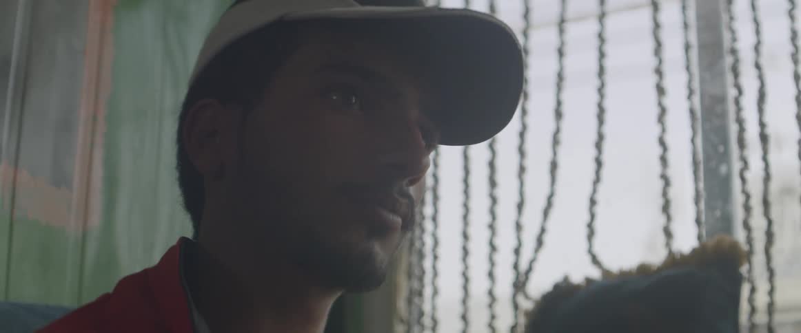 A man stares forward near a window