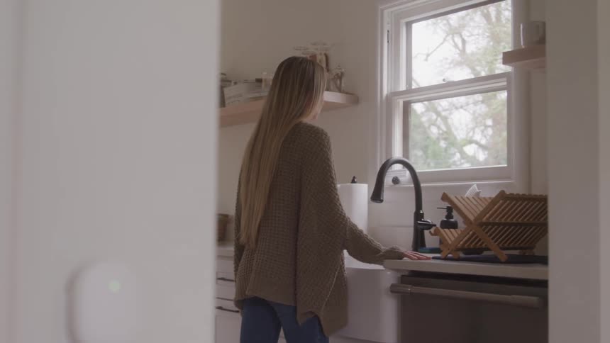 Woman in front of sink in kitchen