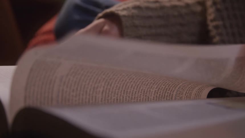 A person turns the pages of a book