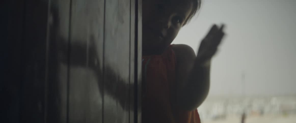 A child slaps the wall with her hand