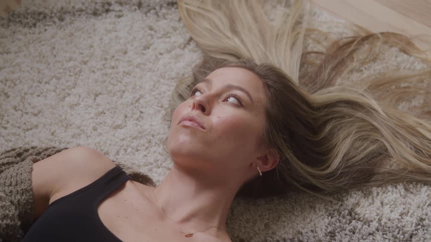 A woman lays on the carpet her hair splayed out
