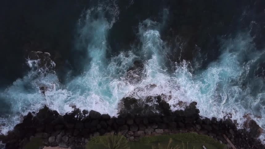 Waves crash against the rocky shore below