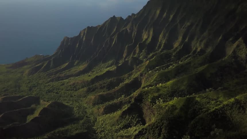 A rolling, grassy mountain valley under some clouds