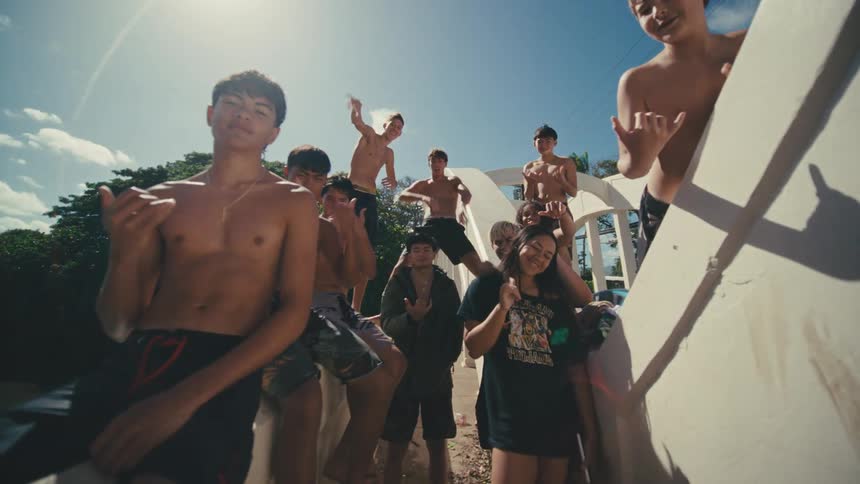 A group of teenagers are waving on the bridge