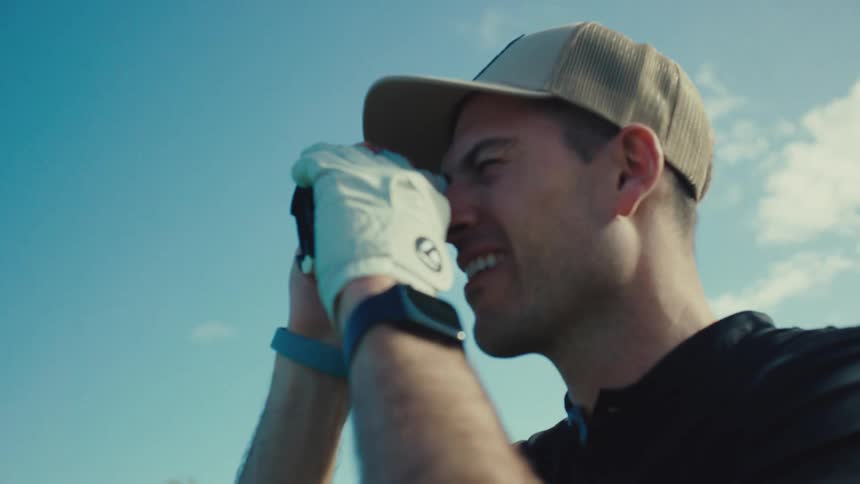 The golfer uses a binocular