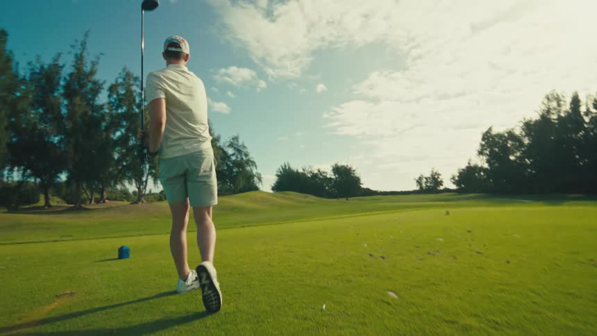 The man is driving golf balls on the course