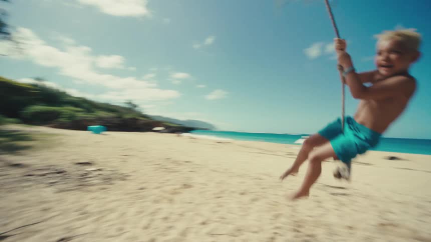 Child playing on a swing with his father