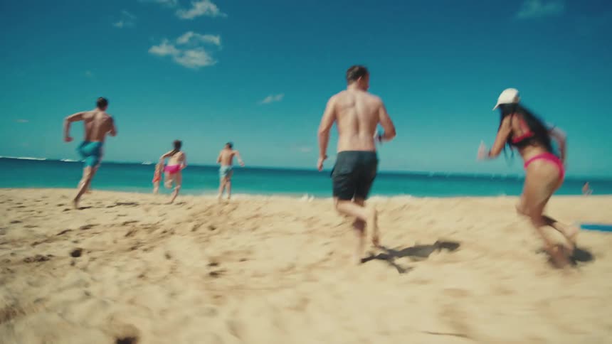 The people race towards the water on the beach