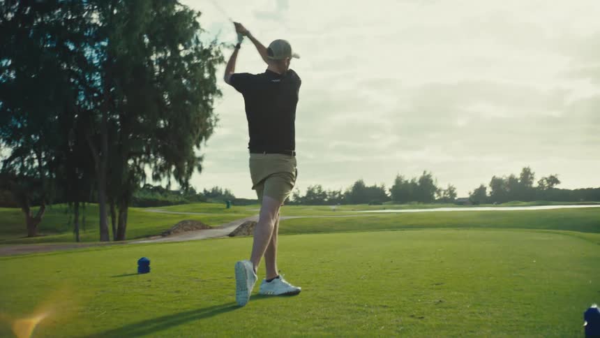 The golfer drives the ball down the field