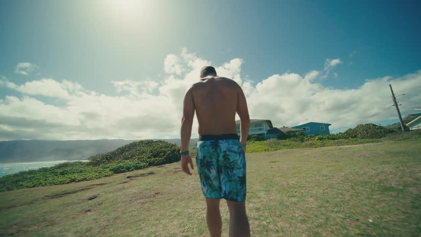 The man is walking towards the villa on the shore