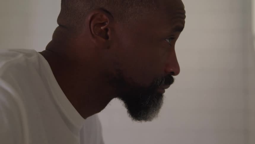 The man wearing a white shirt looks up