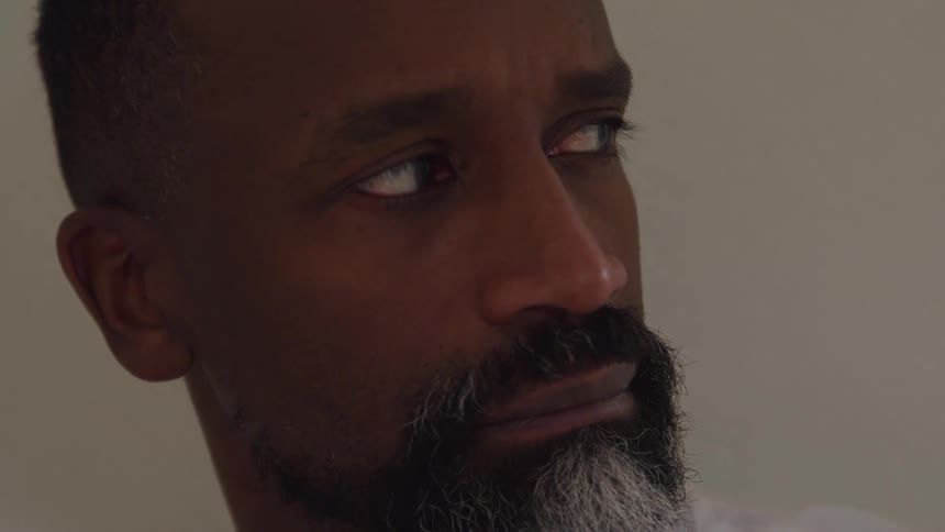 The man slowly turns his head to the side