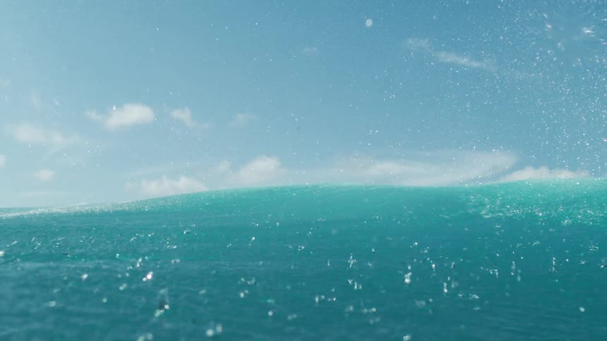 View from the sea of a turquoise blue wave passing through the ocean