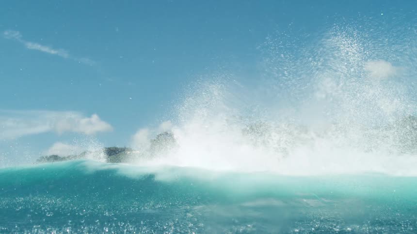 A large blue wave hits the island shore