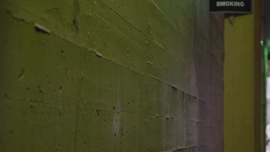 The yellowpainted wall of a building is suddenly struck by an object