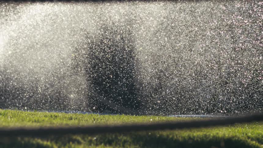 Water sprays on the green grass