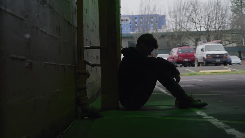 Man sitting in a covered parking lot
