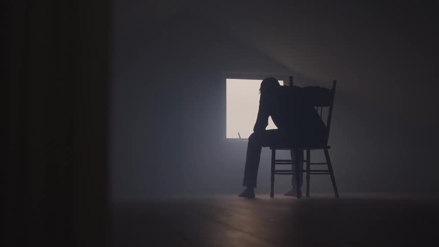Man sitting in a chair looking out the window