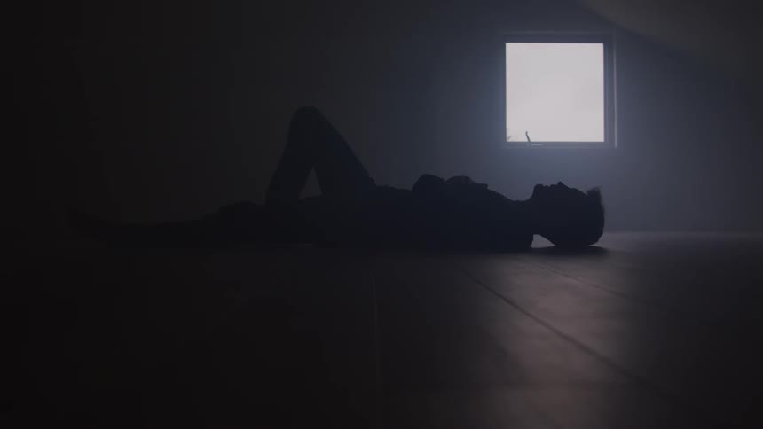 Man lying on his back with his knees up moves his hand underneath his head