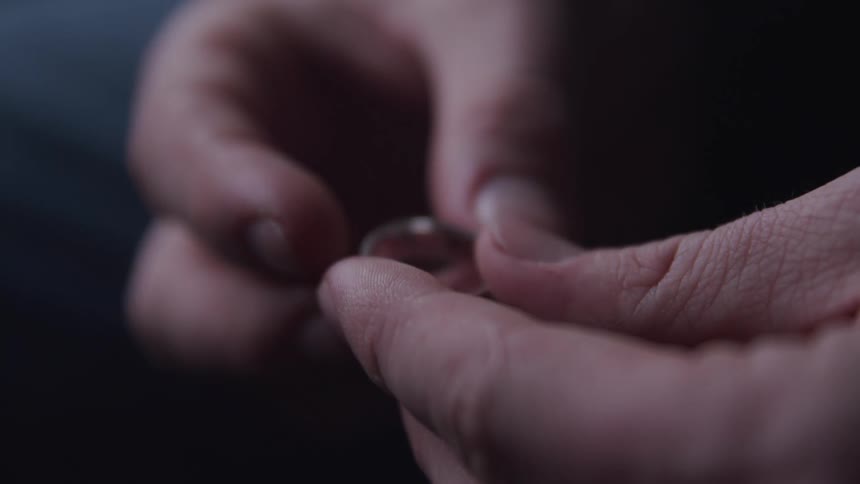 Close up of a pair of hands holding a ring