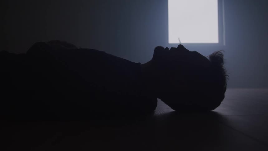 Silhouette of a man lying on the ground