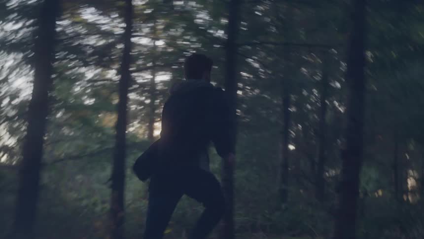 Person running in the forest at dusk