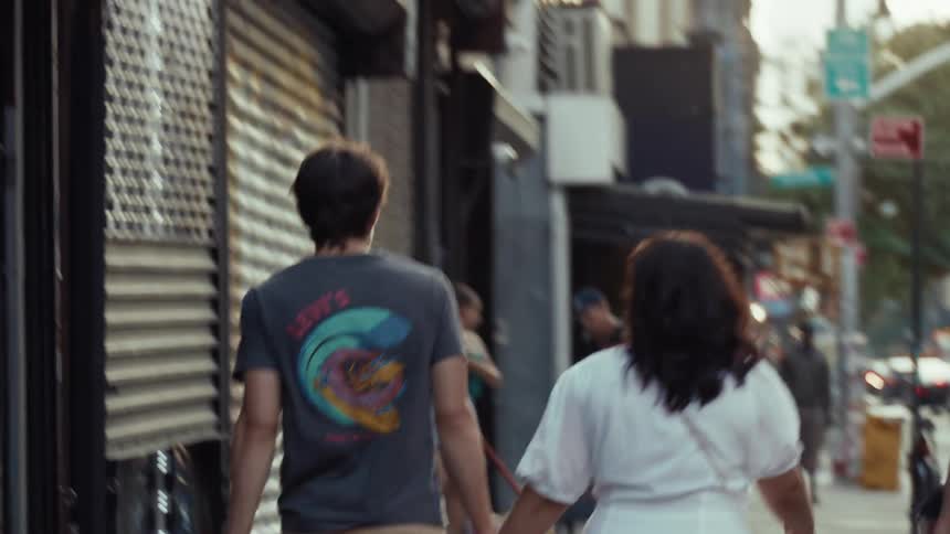 Couple walking through a city with others passing by