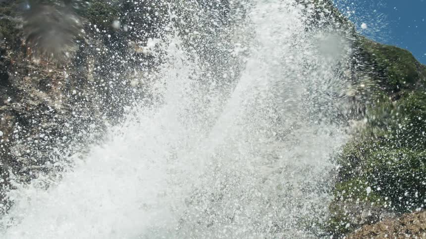 Massive ocean waves crash against steep rocky cliffs