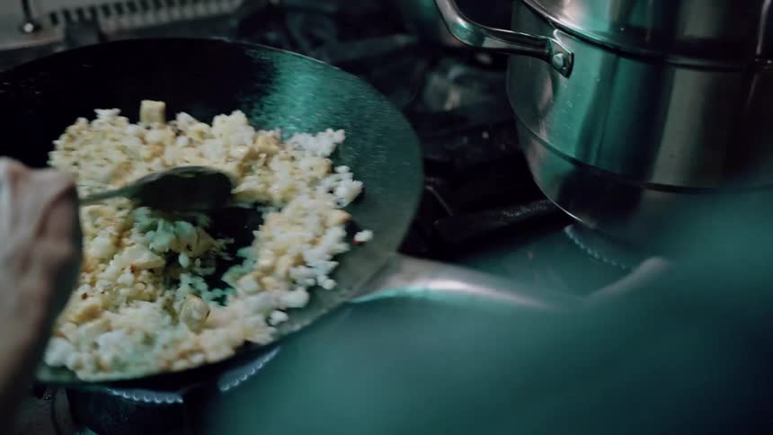 Person holding a ladle and cooking in a pot