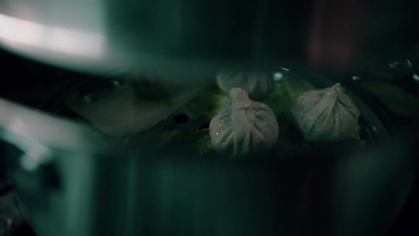 Closeup of dumplings steaming inside a pot