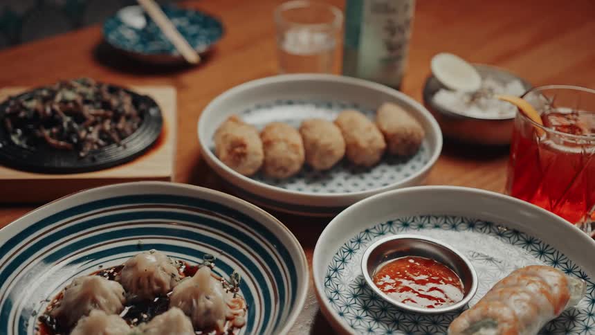 A beautifully arranged table displays crispy croquettes rice grilled vegetables and drinks