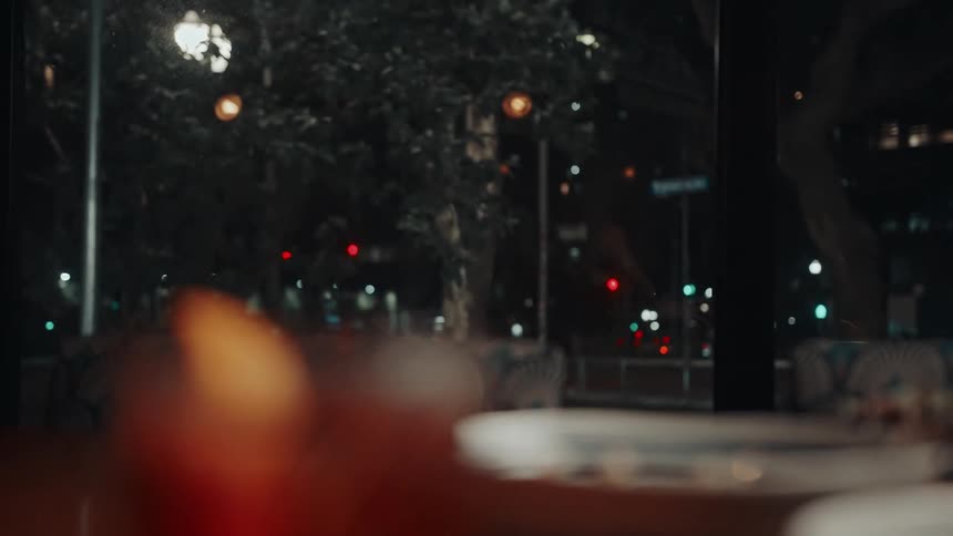 A drink and food are on the restaurant table at night