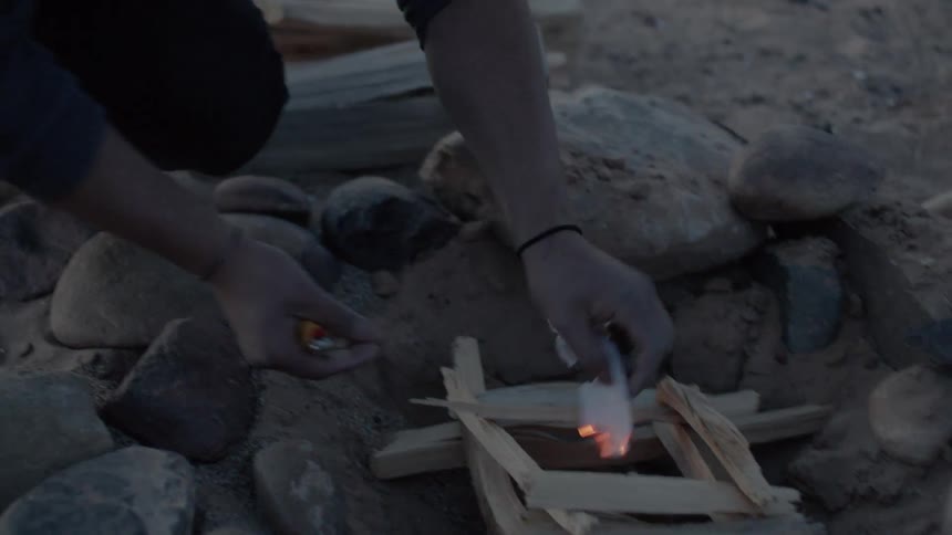 A person starting a campfire